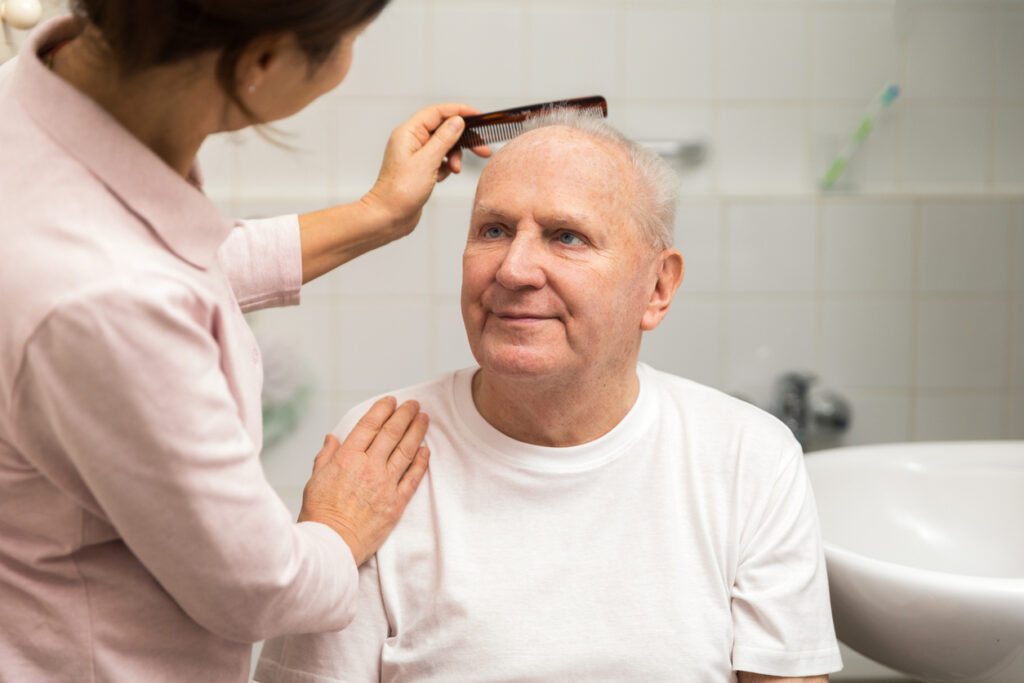 live-in-carer-helping-elderly-man-1024x683