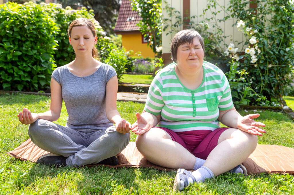 mentally disabled woman and carer doing yoga session